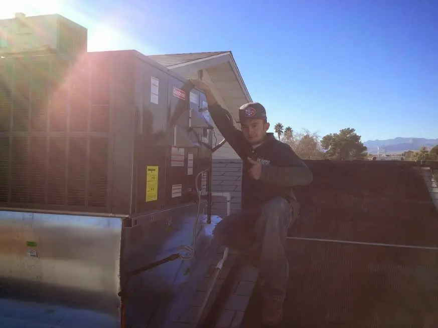 HVAC technician performing Boiler Repair on a rooftop unit in Rockford